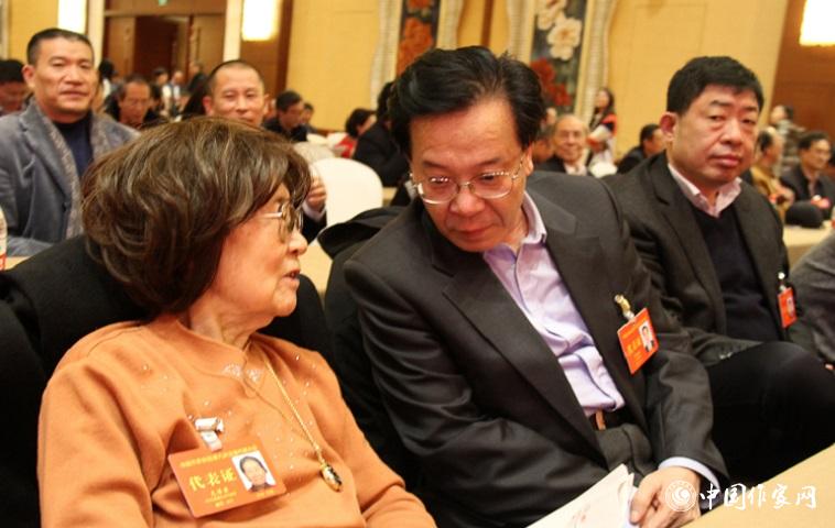 文潔若、李福明等代表在報告會前交談。