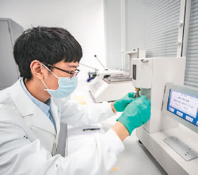  在重慶三峽文物科技保護基地內(nèi)，“文物醫(yī)生”運用各種“診療”設(shè)備對手里的文物進行精準治療，讓其煥發(fā)出新的活力。   圖為2022年，“文物醫(yī)生”利用耐折度儀對紙張的耐折度進行測試。   新華社記者 黃 偉攝