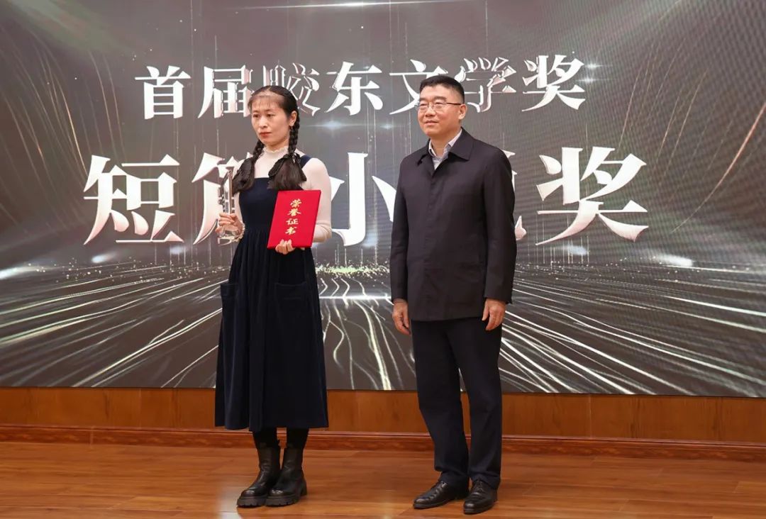 山東省作協(xié)黨組書記、副主席趙藝?。ㄓ乙唬? 為短篇小說獎獲得者王銘嬋頒獎