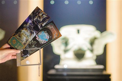 網(wǎng)友手持聯(lián)名款紀念門票及聯(lián)名款透卡與三星堆文物合影