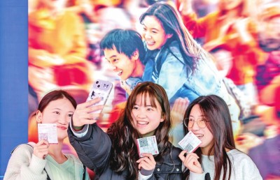 2月18日，觀眾在貴州省黔西市一家影院的電影海報(bào)前留影。 新華社發(fā)