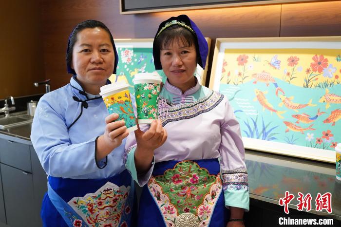 圖為農(nóng)民畫家展示她們被印在星巴克咖啡紙杯上的畫作。中新網(wǎng)記者劉冉陽 攝