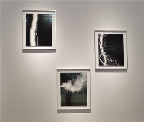 杉本博司“放電場”系列。《筆觸印象·心經(jīng)》之前，藝術(shù)家在暗室中創(chuàng)作“隱形”文本的嘗試早就有跡可循。在2006年開啟的“放電場”系列作品中，杉本博司便已嘗試突破基于鏡頭捕捉的暗室工作方式，用電流導(dǎo)向膠片以獲得圖像。