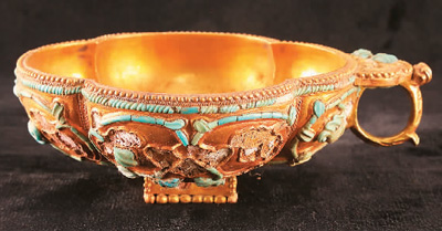 唐吐蕃時(shí)期鑲嵌綠松石四曲鋬指金杯。 　　青海省海西州民族博物館供圖