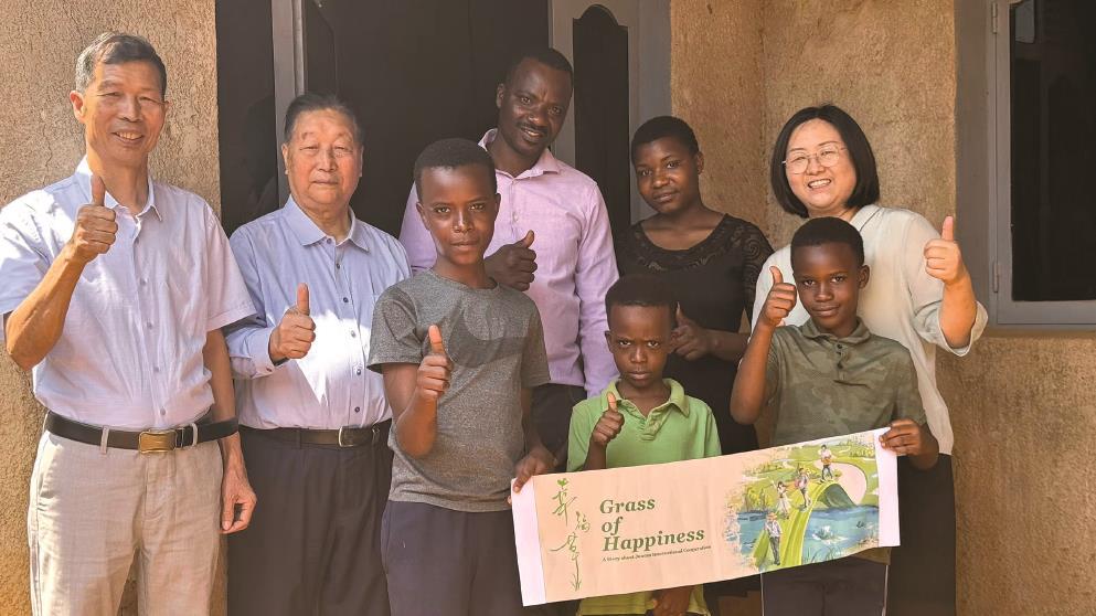 林占熺教授（左二）與盧旺達(dá)當(dāng)?shù)匕傩找黄馂橹袊?電視劇《幸福草》“打call”。（受訪者供圖）