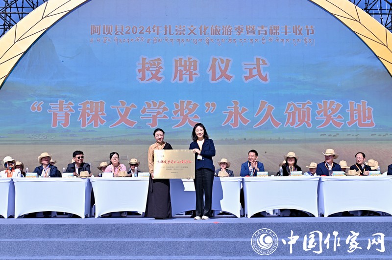 陳亞軍主編代表《民族文學(xué)》向阿壩縣授牌，紅梅部長(zhǎng)接牌。