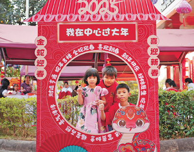 老撾民眾在“歡樂春節(jié)”廟會現(xiàn)場設(shè)立的新春祈福打卡點(diǎn)拍照。  坎帕頌攝