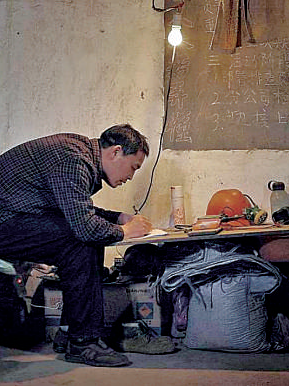 礦工陳年喜在燈下寫作。資料圖片