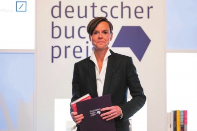     作家安特耶·拉維克·施特魯貝爾在2021年德國圖書獎頒獎典禮上手持《藍色女人》和獲獎證書。攝影：托馬斯·洛內(nèi)斯