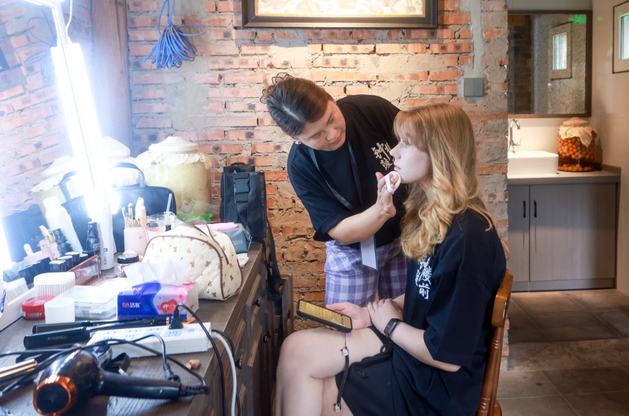 2025年6月30日，百集微短劇《鐘鼓樓前》在北京鼓樓前開機(jī)。圖為俄羅斯籍女演員瑪利亞在開拍前化妝。 中新社記者 賈天勇 攝