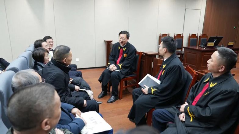 圖為采風(fēng)作家們?cè)诤戏史▌?wù)區(qū)旁聽(tīng)庭審后，與主審法官交流。