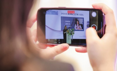在2024上海國際文學(xué)周主論壇的會場，一位觀眾在用手機錄制日本推理小說家湊佳苗的發(fā)言。上海國際文學(xué)周供圖